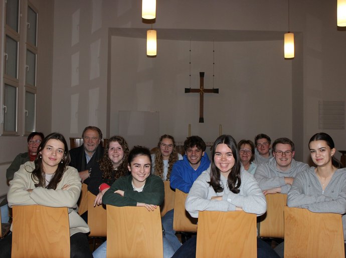 Jugendliche sitzen in der Jugendkirche.