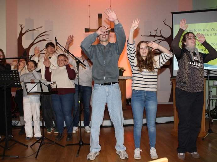 Jugendliche musizieren und bewegen sich in der Kirche.
