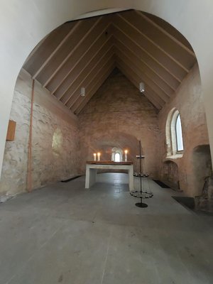 Blick in den Altarraum der Kirche in Hanerau-Hademarschen mit Altar, auf dem Kerzen brennen