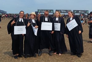 Vier Pastorinnen und ein Pastor auf dem Infield, dahinter ein Eingangsbereich