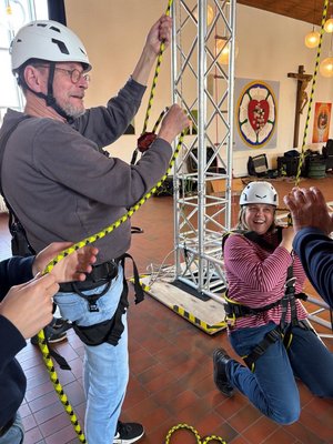 Ein Mann und eine Frau mit Helm in Klettergürteln