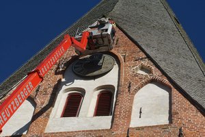 Blick auf einen Hubsteiger am Kirchturm bei der Demontage der Kirchturmuhr.