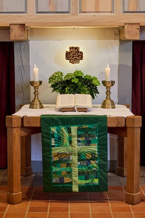 Der Altar, zwei Kerzen und das gut ausgeleuchtete Kreuz