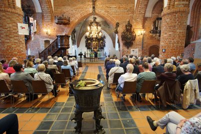 Blick auf vollbesetzte Stuhlreihen in der Kirche St. Nicolai